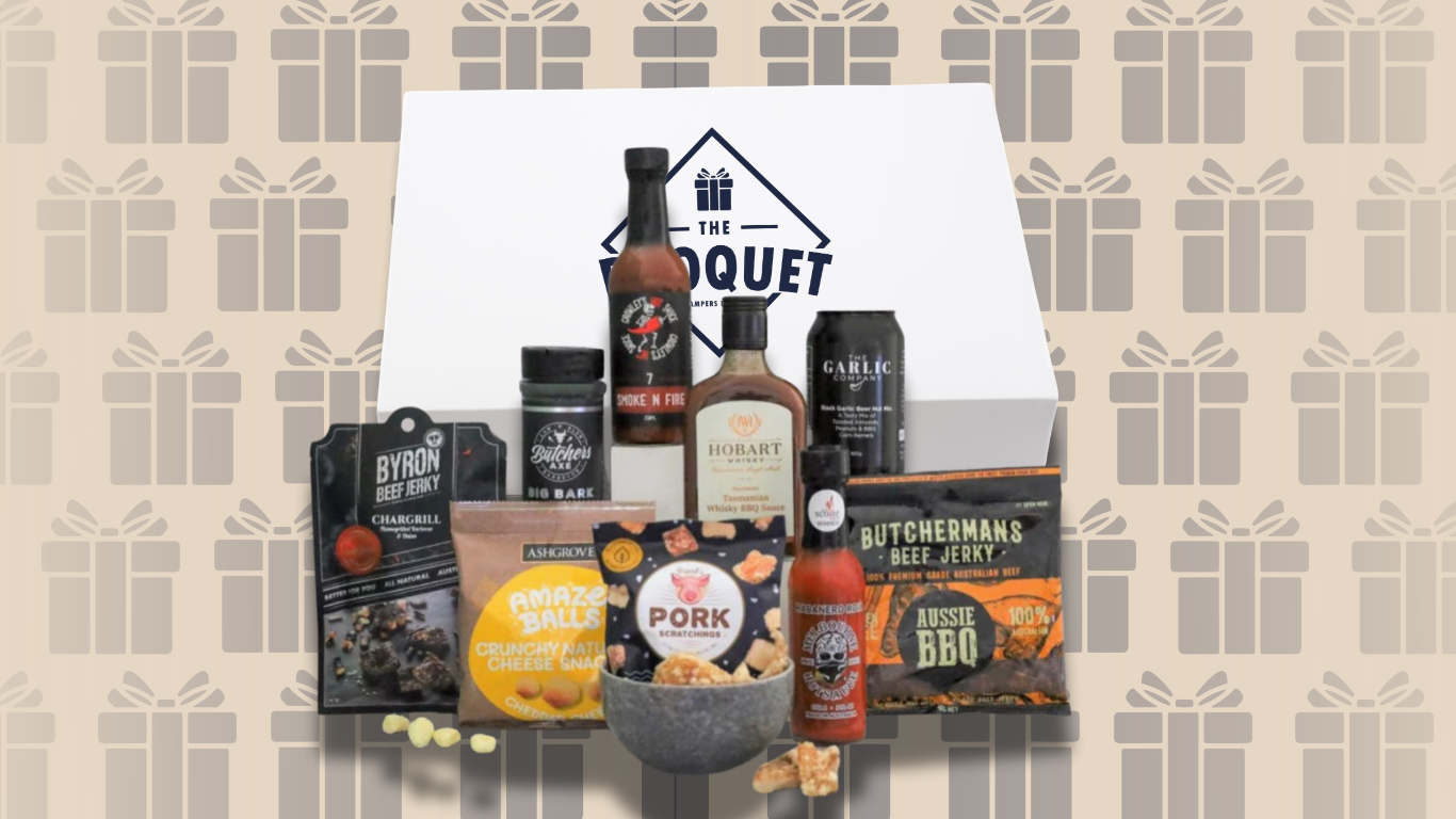 Gift box with various products including bottles and a bowl on a patterned background